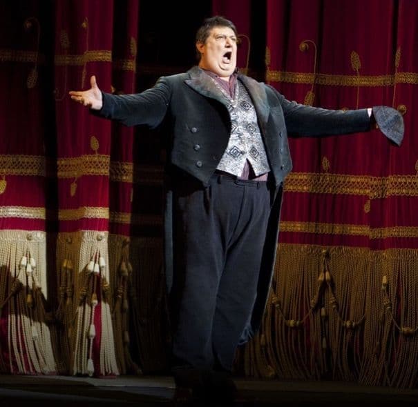 Prologo. Di fronte al sipario del Teatro chiuso, Tonio, con il suo costume di scena che più avanti indosserà per interpretare Taddeo. È in piedi, rivolto verso il pubblico, con le braccia allargate. È un uomo alto e robusto, con i capelli corti castano scuro. Indossa una camicia rosso scuro, a righe bianche, e un gilet di colore argento, con delle decorazioni a forma di rombo di colore nero. Sopra, una giacca da frac molto corta, di velluto, di colore grigio scuro, tenuta aperta. Il bavero della giacca è a scacchi, grigi e neri. Sotto, dei pantaloni lunghi, di velluto, di colore grigio scuro. Nella mano sinistra stringe un berretto a cuffia, di colore grigio.