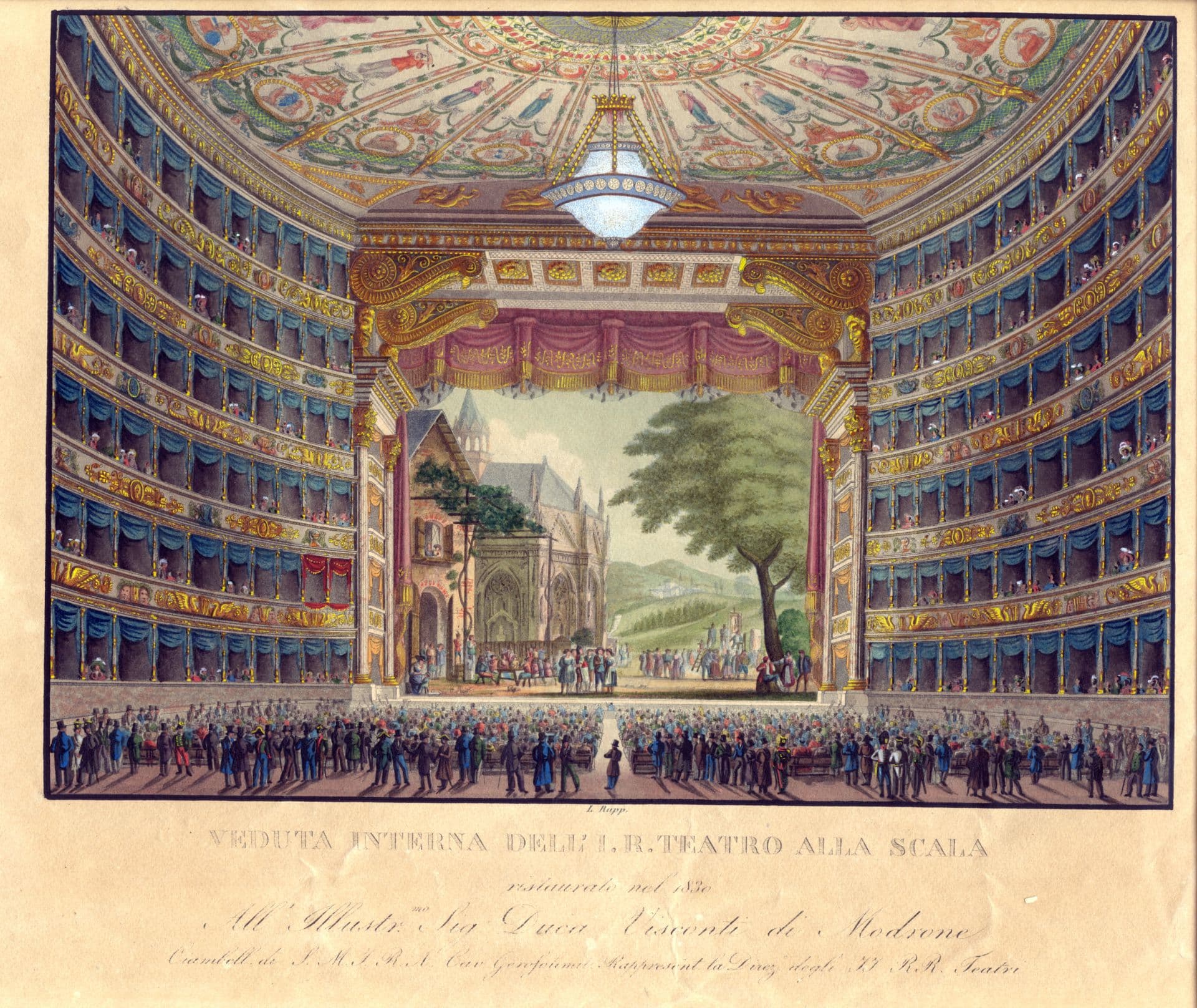 L'immagine mostra una veduta d’insieme dell’interno del Teatro alla Scala, dal fondo della platea. Si tratta del riallestimento effettuato nel 1830 che ha visto i palchi e il loggione arricchiti di drappeggi blu. La platea è piena di persone, in gran parte sedute su panche a più posti, ma anche in piedi, sul fondo. Sul soffitto, al centro della platea, c’è il grande lampadario che fu collocato nel 1823, con 84 lumi a petrolio. Sul palco, le scenografie mostrano a destra un grande albero con chioma verde in primo piano e più indietro un paesaggio collinare. A sinistra, una grande casa con due persone affacciate alla finestra sopra al portone e, più indietro, una cattedrale. Il palco è popolato da una moltitudine di persone, in parte in piedi e in parte sedute.